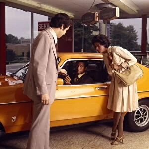 Small Group Of People Gallery: African-American Couple Buy New Orange Car From A Salesman At Automobile Dealer Showroom