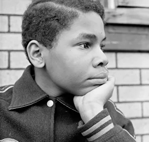 African-American teenage boy resting chin in hand, looking off to side African-American teenage boy resting chin in hand, looking off to side