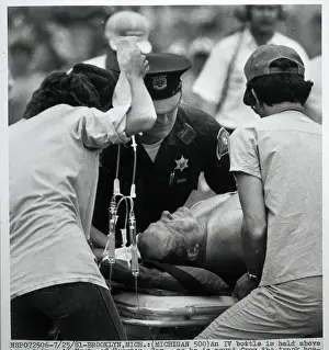 Foyt Prints: A.J. Foyt Being Moved on Gurney at Track