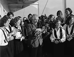 Prints of (Original Caption) 1/28/1932-Prof. Albert Eisnstein is shown amongst a group of women. He is holding a bouquet of flowers A Glimpse into Genius: Albert Einstein Holding Flowers