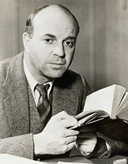 American Author John Dos Passos Pausing with Book in Hand