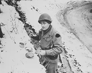 Unpaved Road Prints: American Soldier Eating Food Along Road in Belgium