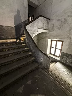 Ancient spiral stairs with a human shade