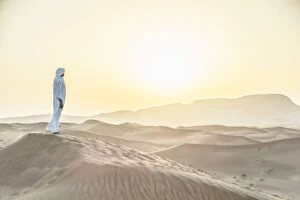 Images Dated 15th March 2013: Arab man standing in sand dunes near Dubai