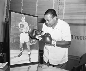 Archie Moore Punching at Picture of Rocky Marciano