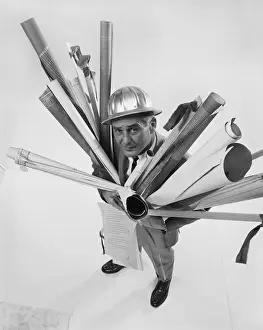 Rolled Up Prints: Architect holding blueprints, smiling, portrait