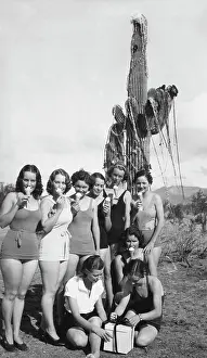 Prints of Here in Arizona the local belles use a Saguaro cactus decorated with tinsel and red ribbon for a Christmas tree, and wear bathing suits and eat ice cream cones while opening their presents, Mesa Celebrate the Season: A Curated Collection of Christmas Art: Arizona Desert Christmas Scene