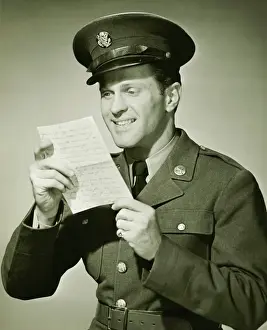 Us Military Prints: US Army solider reading letter in studio, (B&W), portrait