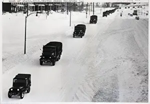 Blizzard Prints: Army Vehicles Driving On Snowy Street