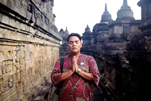Magelang Prints: Asian man in traditional dress posed at Borobudur temple