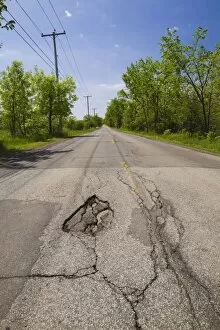 Asphalt road with pothole in the countryside, Quebec, Canada