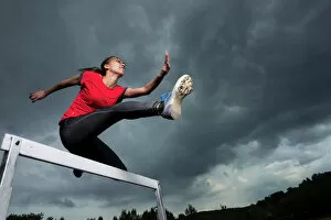 Cloudy Sky Collection: Athlete, 20 years, jumping hurdles, Winterbach, Baden-Wurttemberg, Germany