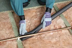 Glove Prints: Attaching pipe insulation to a copper pipe above joists and insulation blanket