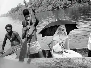 Prints of Actress Audrey Hepburn in a scene of the movie 'The Nun's Story' in 1958 in The Republic of Congo in 1958. (Photo by Leo Fuchs/Archive Photos/Getty Images) Elegance Personified – A Classic Art Print Collection: Audrey Hepburn With Natives On Canoe