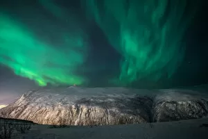 Images Dated 3rd August 2018: Aurora Borealis on a starry night behind a mountain, Tromso, Norway