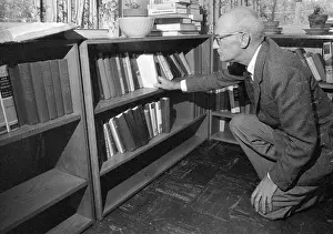 Author C. S. Forester Selecting a Book from Bookshelf