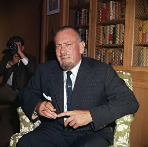 Author John Steinbeck near Bookshelf