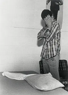 Autistic Young Man Covering His Face in Frustration