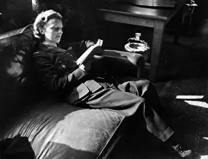 Prints of 1942: A woman Air Transport Auxiliary pilot relaxing with a good book. Original Publication: Picture Post - 1110 - Air Transport Auxiliary - unpub Discover the Vision of Haywood Magee – A Master of Mid-Century British Life: Away From It All