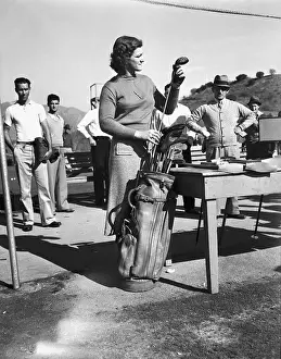 Babe Didrikson Examining Golf Clubs