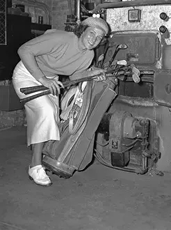 Babe Didrikson Putting Golf Clubs in Furnace