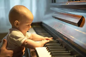 Baby, 4-5 months old, at a piano, Germany