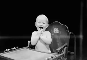 6 11 Months Prints: Baby boy (6-11 months) sitting in high chair and laughing