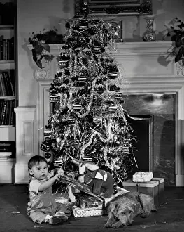 Baby beside a Christmas tree