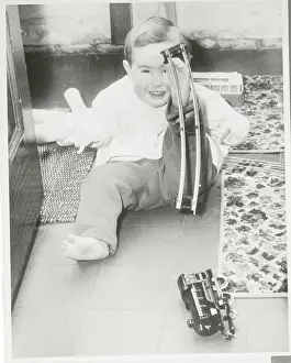 Thalidomide Prints: Baby Lifting Model Railroad Track with Foot