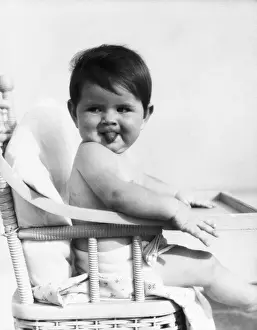 Chair Prints: Baby sitting in high chair, sticking out tongue