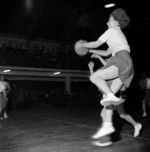Prints of 7th March 1953: A netball player jumping with the ball, during a match against the Surrey County Netball team at Wimbledon A Photographic Legacy: Ball Jump