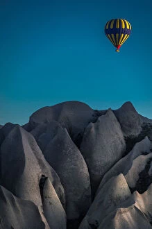 a balloon flying over a volcanic rock