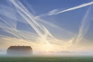 Barn, condensation trails in the sky, sunrise in Basse, Lake Mariensee, Neustadt am Ruebenberge, Lower Saxony, Germany