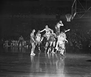 Prints of (Original Caption). High Flying. New York, New York: Yale's Dick Joyce grabs rebound on the fly in scramble under basket in first half of consolation playoff at Garden Hoops Through Time: A Visual Journey of Basketball History: Basketball Players Scramble for Ball