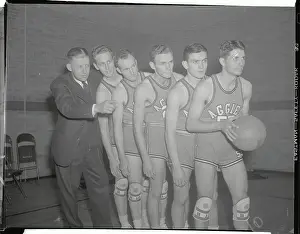 Prints of (Original Caption). The basketballers of Oklahoma A and M who will do battle at Madison Square Garden against the City college of New York strike a warlike pose during a lull in their workout today Hoops Through Time: A Visual Journey of Basketball History: Basketball Teammates and Coach Posing with Ball