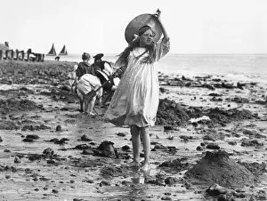 Prints of circa 1895: A young girl taking a break from making sandcastles on the beach. (Photo by F J Mortimer/Getty Images) Francis James Mortimer (1874-1944) Prints: Beach Girl
