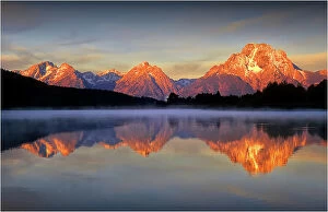 : A beautiful coloured dawn casts its glow over Jackson lake in the Grand Tetons, Wyoming