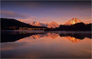 A beautiful coloured dawn casts its glow over Jackson lake in the Grand Tetons, Wyoming