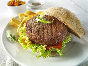 Images Dated 3rd May 2012: Beef burger in a wholemeal bun with salad and french fries