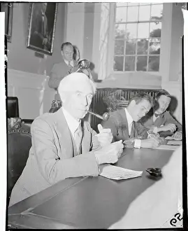 Bertrand Russell Smoking a Pipe at Conference Table