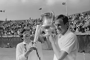 Billie Jean King and John Newcombe Holding Trophies