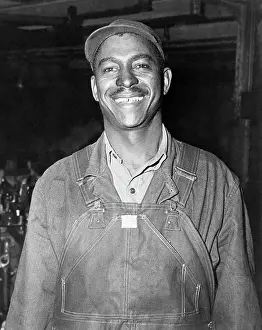 Black Auto-Worker Smiles, Waist Up