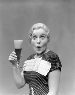Enjoyment Prints: Blonde Woman In Black Dress With Stripes & White Buttons & Trim Holding A Pilsner Glass