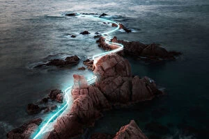 Travel Imagery Gallery: Blue light trail following footpath between the stunning coastline during sunrise