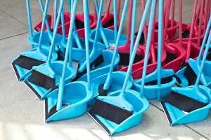 Blue and red brooms with shovels