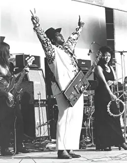 Prints of ENGLAND - CIRCA 1975: Guitarist Bo Diddley flashes peace signs as he performs onstage with his trademark square Gretsch electric guitar in circa 1975 in England Bo Diddley: Rhythm & Riffs Prints: Bo Diddley Performs In England