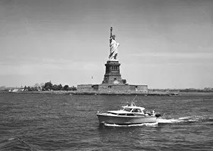 Boat floating by Statue of Liberty, New York City, USA, (B&W)