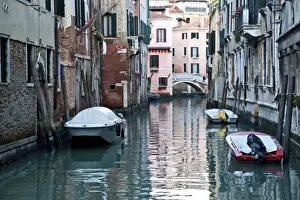 Boats moored along buildings in a tranquil canal