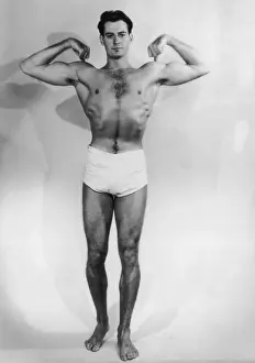 Prints of A muscular young man flexes his biceps, circa 1930. (Photo by FPG/Hulton Archive/Getty Images) Black and White Images Capturing the Essence of Mid-20th Century: Body Beautiful