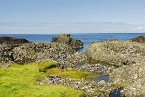 Harbour Prints: Bog pools in weathered basalt blocks at Northern Irish coast at Ballintoy Harbour